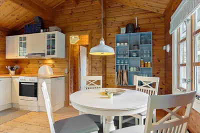 a kitchen and dining room with a white table and chairs at BL969-Blokhus-Bregnehojvej-16 in Blokhus
