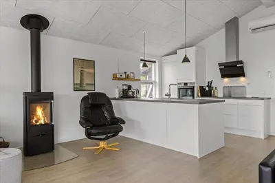 a black chair in a kitchen with a fireplace at BL1315-Saltum-Kordalsvej-43 in Saltum