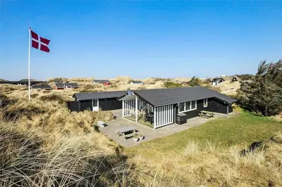a house on the beach with a flag at BL1616-Blokhus-Moreavej-18 in Blokhus