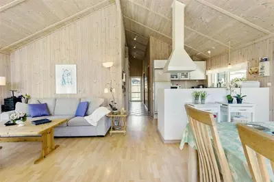 a living room and kitchen with a couch and a table at BL791-Blokhus-Paa-Bakken-3 in Blokhus