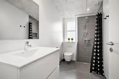 a white bathroom with a sink and a shower at BL1134-Blokhus-Bloksbjerg-17-B in Blokhus