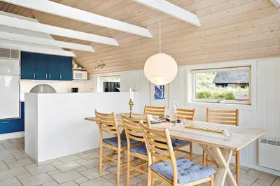 a dining room with a wooden table and chairs at BL830-Pandrup-Bardehvalen-3 in Pandrup