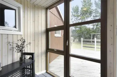 a sliding glass door in a room with a deck at BL1447-Blokhus-Skraavejen-11 in Blokhus