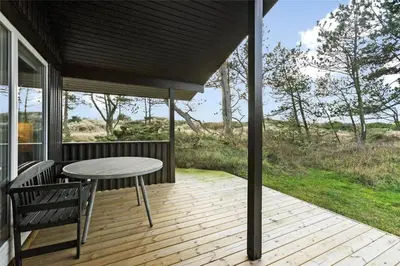 a patio with a table and chairs on a deck at BL1473-Pandrup-Lommelaerken-14 in Pandrup