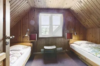 a bedroom with two beds and a window in it at BL1384-Blokhus-Kragebak-7 in Blokhus