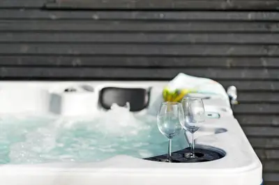 two wine glasses sitting on a table in a bath tub at BL1377-Blokhus-Valmuemarken-37 in Blokhus