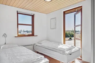 two beds in a white room with two windows at BL451-Saltum-Trehoje-14 in Saltum