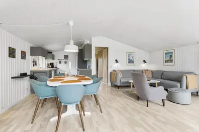 a dining room and living room with a table and chairs at BL1218-Blokhus-Quintusvej-24 in Blokhus