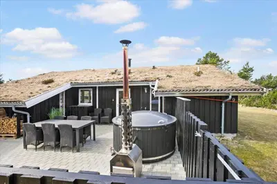 a guitar sitting on a deck next to a hot tub at BL1029-Pandrup-Rodhus-Skolevej-9 in Pandrup