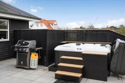 a hot tub and a grill on a fence at BL1355-Blokhus-Ribergaardsvej-24 in Blokhus