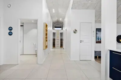 a hallway with white walls and a white tile floor at BL1355-Blokhus-Ribergaardsvej-24 in Blokhus