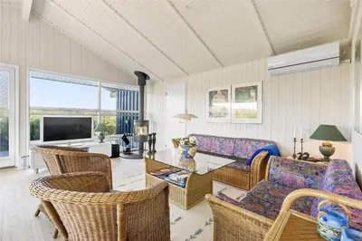 a living room with a couch and a table and chairs at BL1534-Blokhus-Taarnfalkevej-10 in Blokhus