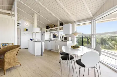 a kitchen and dining room with a table and chairs at BL1534-Blokhus-Taarnfalkevej-10 in Blokhus