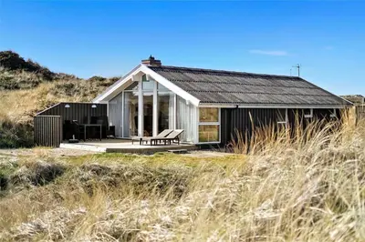 a small house on a beach with tall grass at BL244-Blokhus-Moreavej-17 in Blokhus
