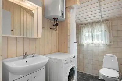 a bathroom with a washing machine and a sink at BL244-Blokhus-Moreavej-17 in Blokhus