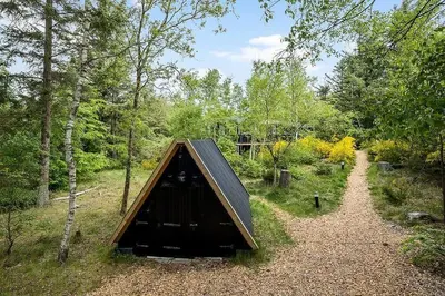 a small cabin in the middle of a forest at BL958-Blokhus-Havorns-Alle-14 in Blokhus