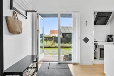 a kitchen with white walls and a large sliding glass door at BL698-Blokhus-Kr-Thomsensvej-3 in Blokhus