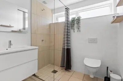 a bathroom with a shower and a toilet and a sink at BL698-Blokhus-Kr-Thomsensvej-3 in Blokhus