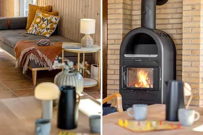 a living room with a fireplace and a couch at BL1232-Blokhus-Pirupvejen-91 in Blokhus