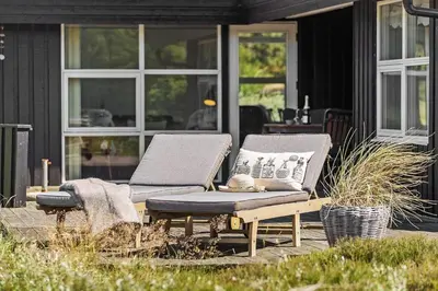 two lounge chairs and a table on a patio at BL1243-Saltum-Kvansletten-22 in Saltum