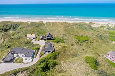 an aerial view of a house on a hill next to the ocean at BL1483-Blokhus-Ved-Skoven-25 in Blokhus