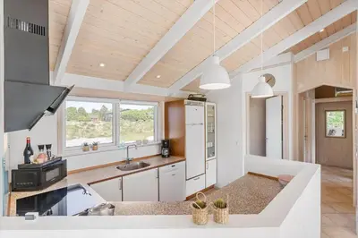 a kitchen with white appliances and a wooden ceiling at BL1761-Blokhus-Hojmarksvej-44 in Blokhus