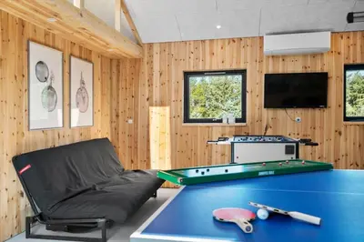 a room with a ping pong table and a couch at BL200-Saltum-Laustvej-9 in Saltum