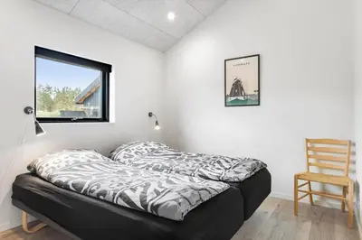 a bed in a room with a chair and a window at BL200-Saltum-Laustvej-9 in Saltum