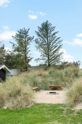 a picnic table and benches in a field of grass at BL1713-Blokhus-Ingersvej-8 in Blokhus