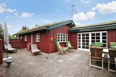 a patio with chairs and a red building at BL1743-Pandrup-Rodhus-Skolevej-14 in Pandrup