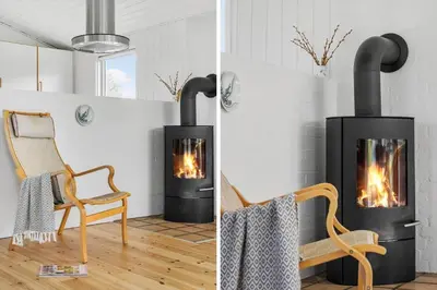 a fireplace and a chair in a room at BL1471-Blokhus-Solbakkevej-15 in Blokhus