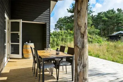 a wooden table and chairs on a deck at BL1704-Blokhus-Pirupvejen-66 in Blokhus