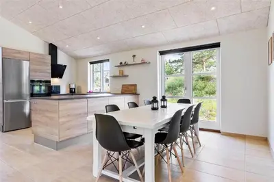 a kitchen and dining room with a table and chairs at BL1704-Blokhus-Pirupvejen-66 in Blokhus