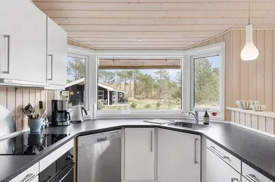 a kitchen with white cabinets and a large window at BL1262-Pandrup-Hunetorp-Klitvej-5 in Pandrup