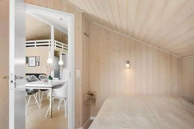 a bedroom with a bed and a table in a room at BL1262-Pandrup-Hunetorp-Klitvej-5 in Pandrup
