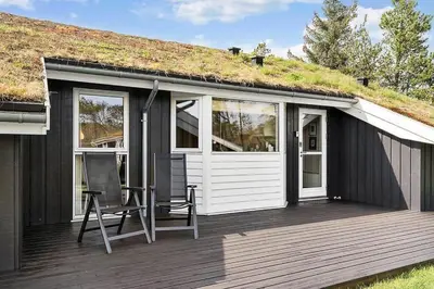 a house with a grass roof with a deck at BL1262-Pandrup-Hunetorp-Klitvej-5 in Pandrup