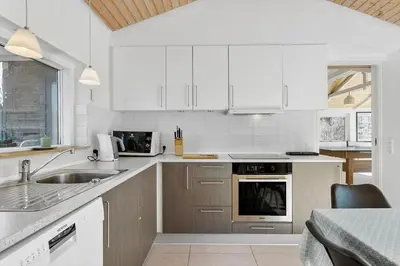 a kitchen with white cabinets and a sink at BL1236-Pandrup-Kirkekrogen-5 in Pandrup