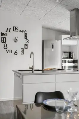 a kitchen with a table and a clock on the wall at BL191-Blokhus-Bloksbjerg-13 in Blokhus