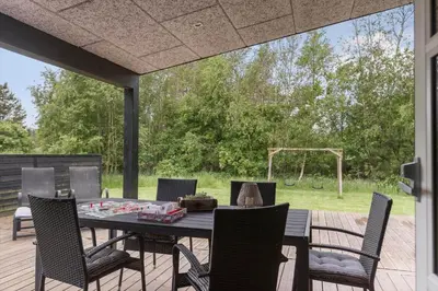 a patio with a table and chairs on a deck at BL191-Blokhus-Bloksbjerg-13 in Blokhus
