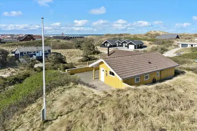 a yellow building on the side of a hill at BL1747-Blokhus-Norresundbyvej-22 in Blokhus