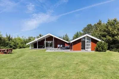 a house on a grassy field with a picnic table at BL410-Saltum-Store-Fiskerbanke-4 in Saltum