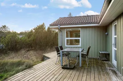a wooden deck with a table and chairs on it at BL1233-Saltum-Krogsletten-14 in Saltum