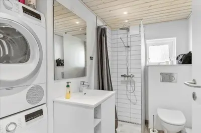 a bathroom with a sink and a washing machine at BL1417-Blokhus-Frederiksensvej-16 in Blokhus