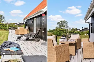 a deck with chairs and a table and a house at BL1549-Blokhus-Bakkevaenget-11 in Blokhus