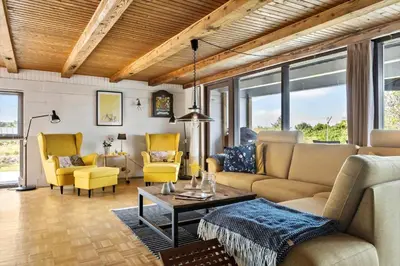 a living room with a couch and yellow chairs at BL1549-Blokhus-Bakkevaenget-11 in Blokhus
