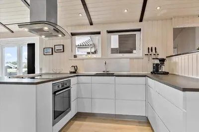 a kitchen with white cabinets and a sink at BL239-Blokhus-Klitgaardsvej-21 in Blokhus