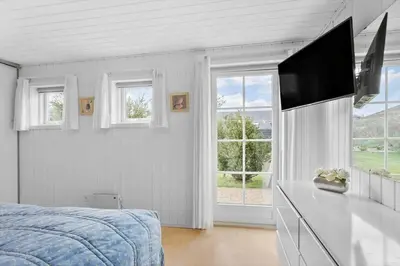 a bedroom with a bed and a flat screen tv at BL856-Blokhus-Soren-Tjenersvej-2 in Blokhus