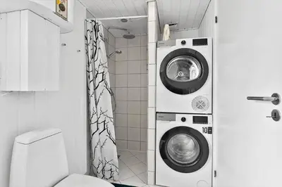 a bathroom with a washing machine and a shower at BL856-Blokhus-Soren-Tjenersvej-2 in Blokhus