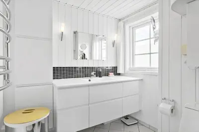 a white bathroom with a sink and a mirror at BL856-Blokhus-Soren-Tjenersvej-2 in Blokhus