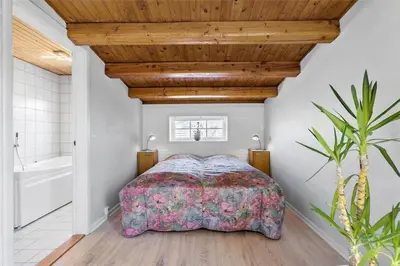 a bedroom with a bed and a wooden ceiling at BL141-Blokhus-Vigen-12 in Blokhus